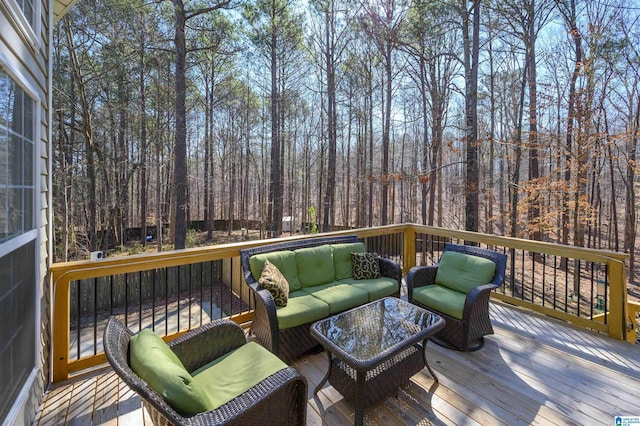 wooden deck featuring an outdoor living space and a wooded view