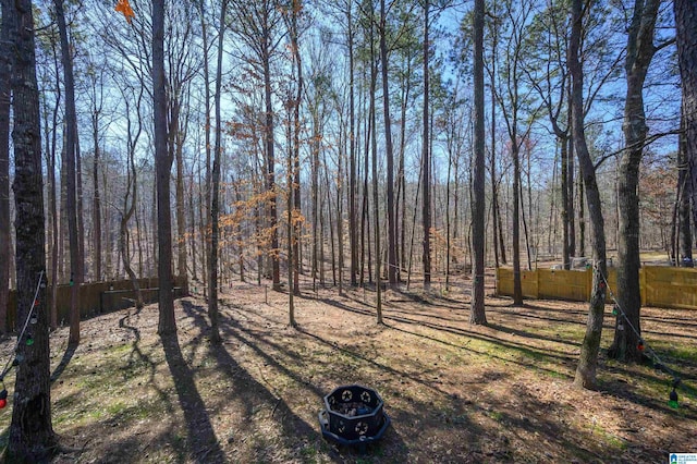 view of yard featuring fence and a view of trees