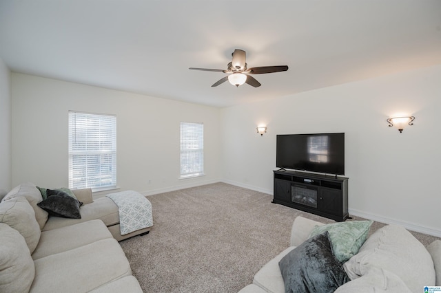 carpeted living room featuring a ceiling fan and baseboards