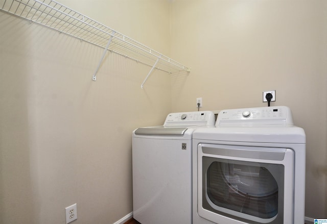 laundry area featuring laundry area, washing machine and dryer, and baseboards