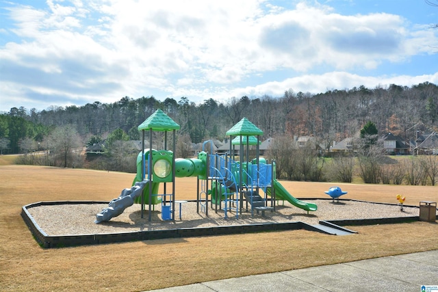 community play area with a forest view and a lawn