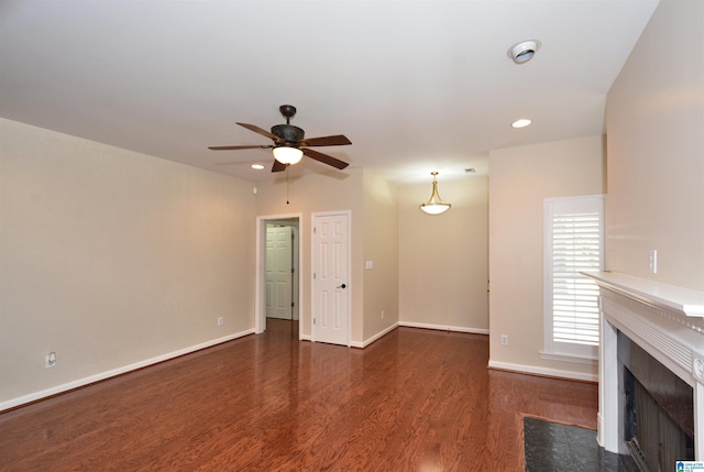 unfurnished living room featuring ceiling fan, recessed lighting, a premium fireplace, wood finished floors, and baseboards