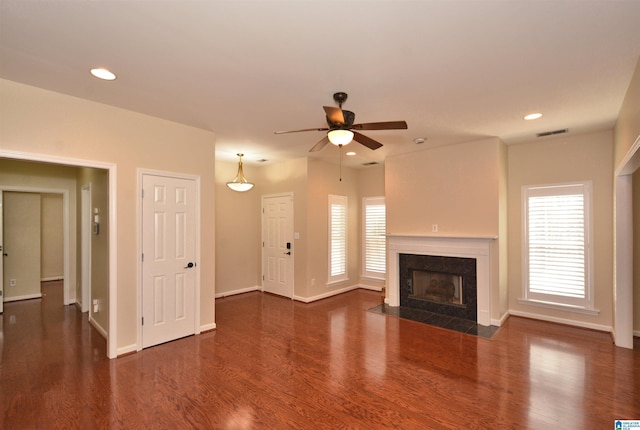 unfurnished living room featuring baseboards, visible vents, a high end fireplace, dark wood-style flooring, and recessed lighting