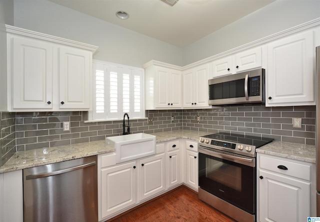 kitchen featuring stainless steel appliances, dark wood-type flooring, a sink, and white cabinets