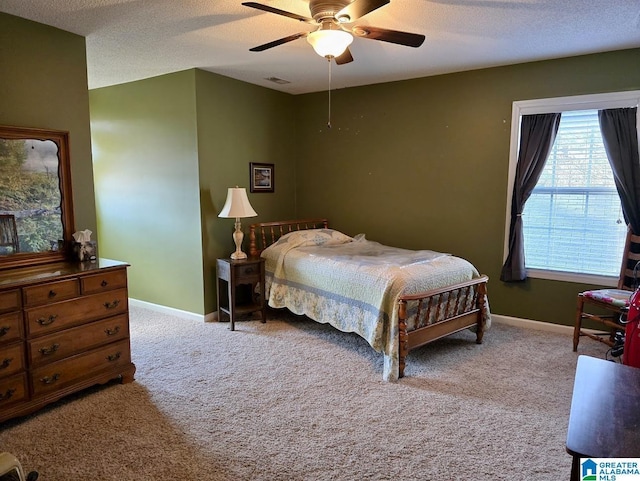 carpeted bedroom with a textured ceiling, ceiling fan, visible vents, and baseboards