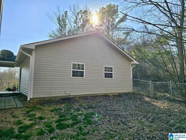 view of property exterior with fence and a gate