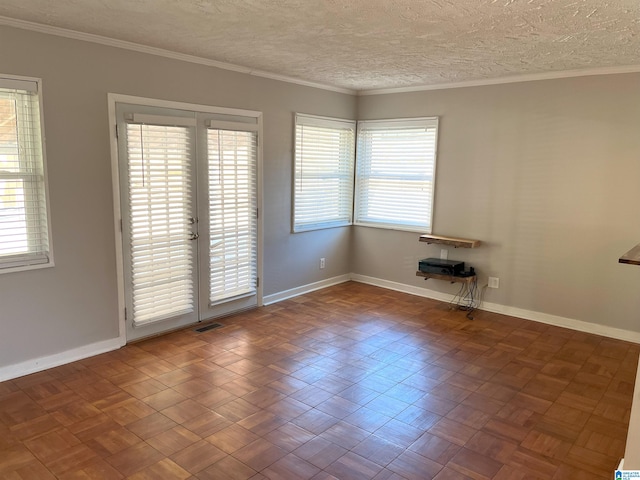 spare room with visible vents, crown molding, a textured ceiling, and baseboards