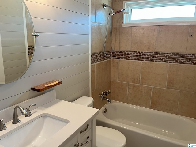 bathroom with toilet, shower / tub combination, wooden walls, and vanity