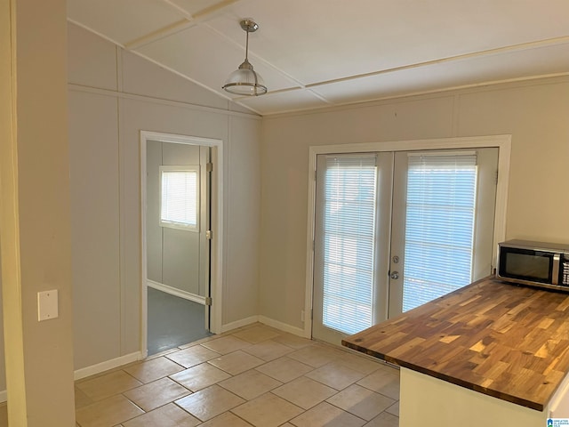 entryway featuring light tile patterned flooring, vaulted ceiling, and french doors