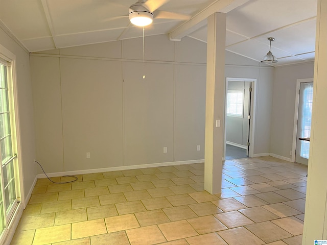 empty room with a wealth of natural light, lofted ceiling with beams, and light tile patterned floors