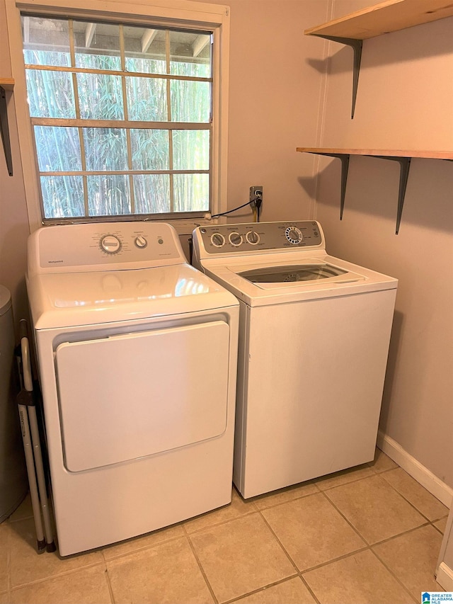 laundry room with laundry area, baseboards, washing machine and clothes dryer, and light tile patterned floors