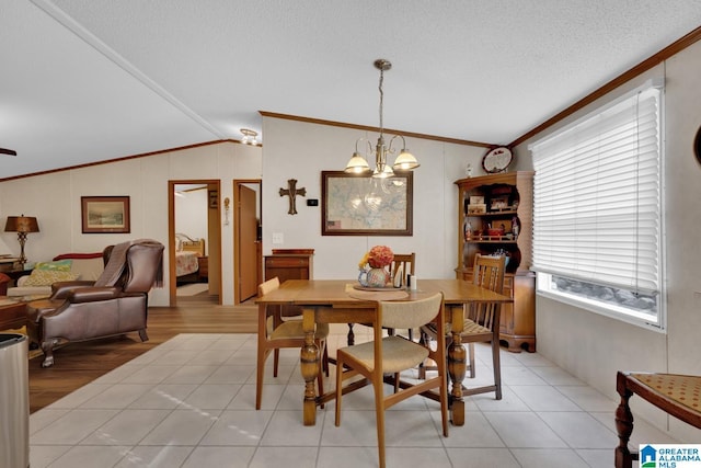 dining room with ornamental molding, vaulted ceiling, a textured ceiling, a notable chandelier, and light tile patterned flooring