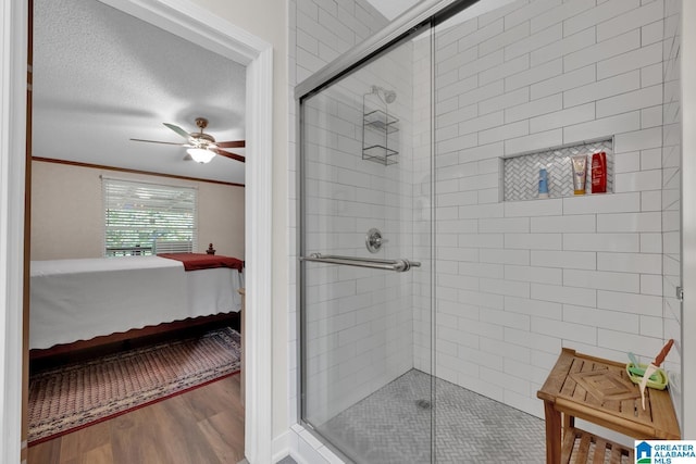 bathroom with wood finished floors, crown molding, a shower stall, and ensuite bathroom