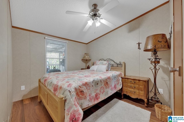 bedroom featuring lofted ceiling, wood finished floors, a ceiling fan, and crown molding