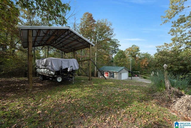 view of yard featuring an outbuilding, a detached garage, and driveway