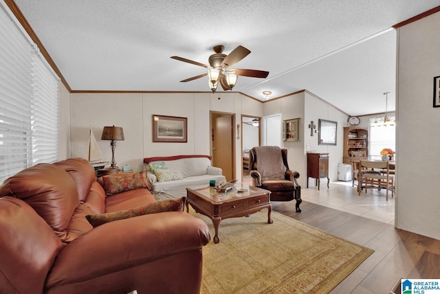 living room with a textured ceiling, vaulted ceiling, crown molding, and wood finished floors