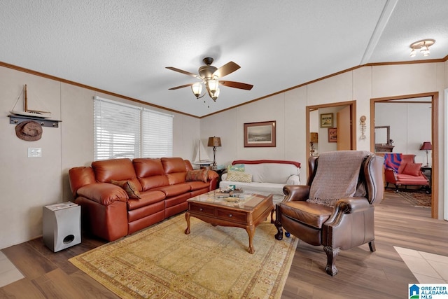 living area with ornamental molding, a ceiling fan, vaulted ceiling, a textured ceiling, and wood finished floors