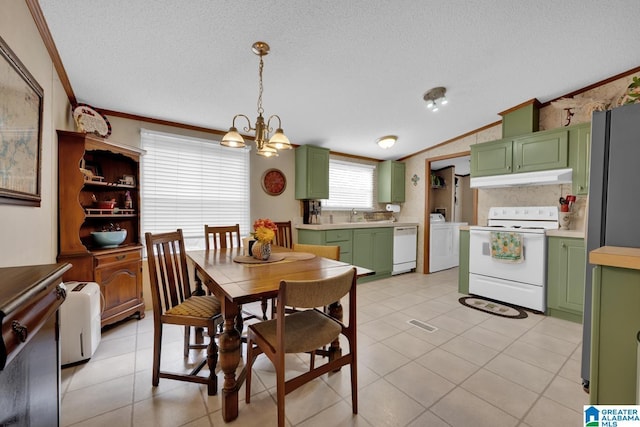 dining area featuring lofted ceiling, ornamental molding, a textured ceiling, and washer / dryer