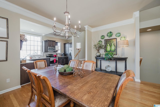 dining room featuring light wood-style floors, baseboards, and ornamental molding