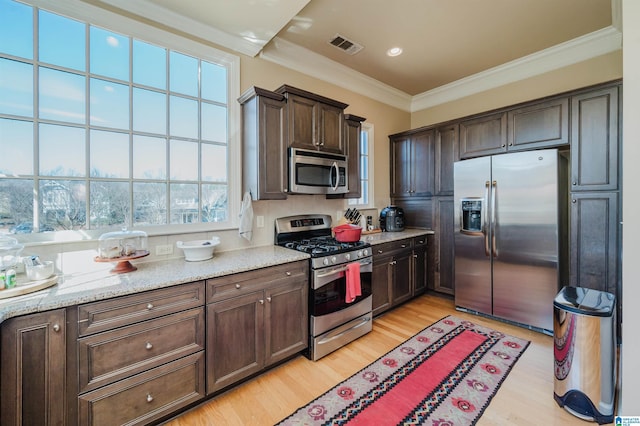 kitchen with light wood-style flooring, visible vents, dark brown cabinets, ornamental molding, and appliances with stainless steel finishes