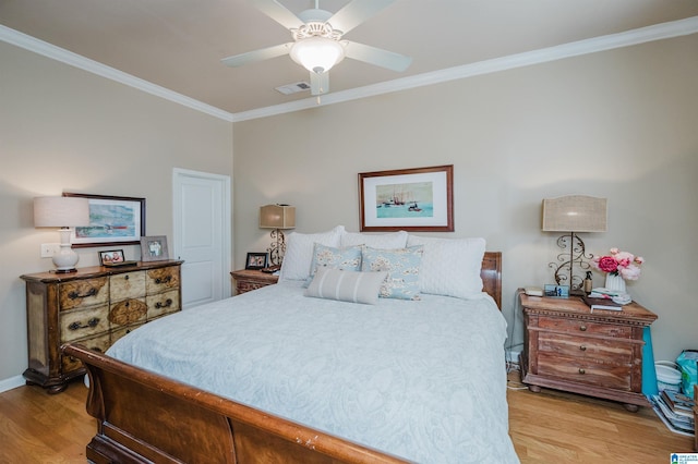 bedroom featuring a ceiling fan, baseboards, visible vents, light wood-type flooring, and crown molding