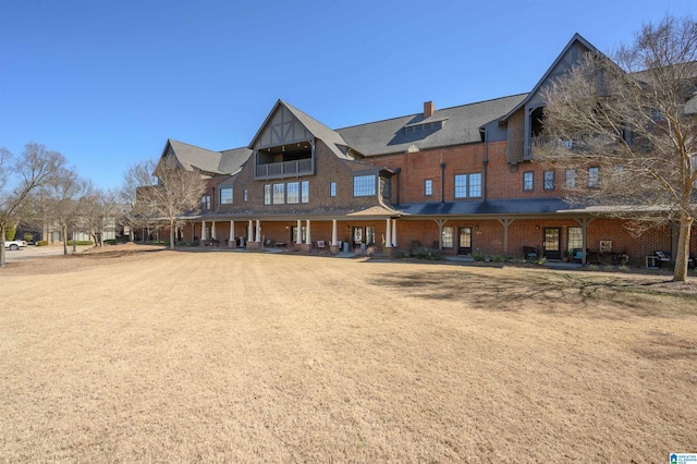 rear view of property with brick siding and a chimney