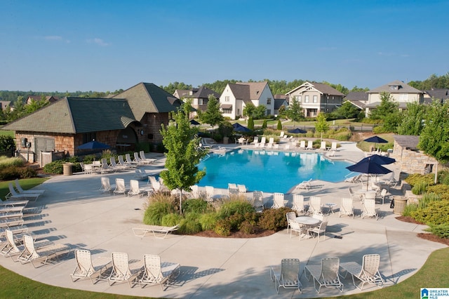 community pool with a residential view and a patio