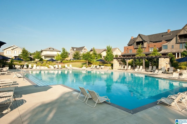 community pool with a residential view and a patio area