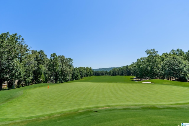 view of home's community featuring view of golf course and a lawn