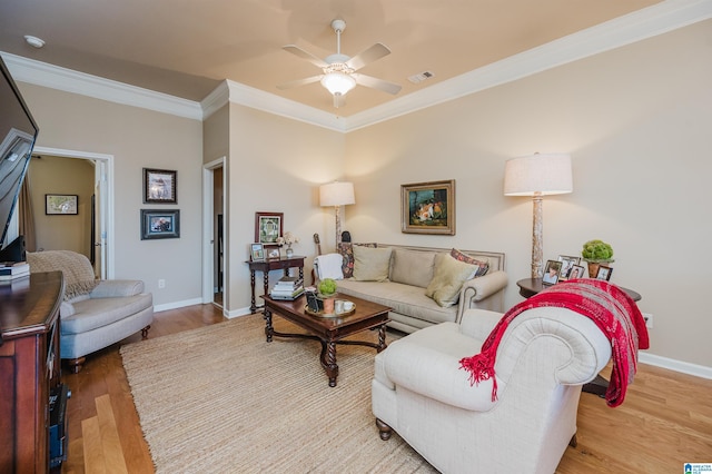 living area with visible vents, ornamental molding, ceiling fan, wood finished floors, and baseboards