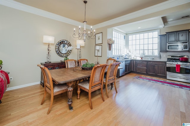 dining room with an inviting chandelier, light wood-style flooring, baseboards, and crown molding