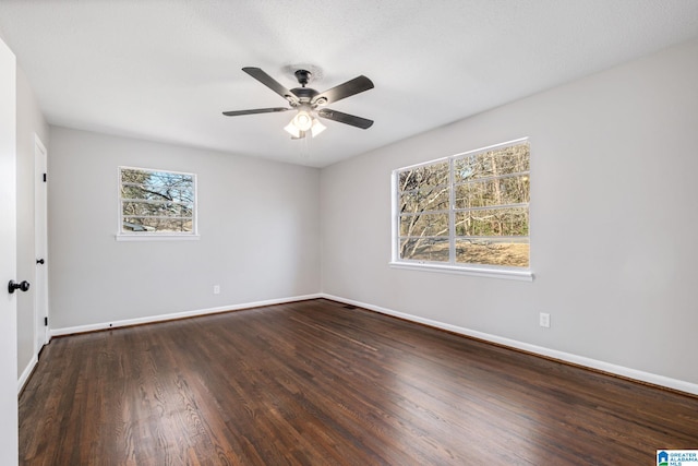 unfurnished room with plenty of natural light, baseboards, and wood finished floors