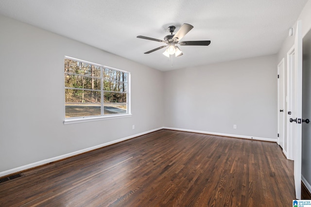 unfurnished bedroom with ceiling fan, dark wood finished floors, visible vents, and baseboards