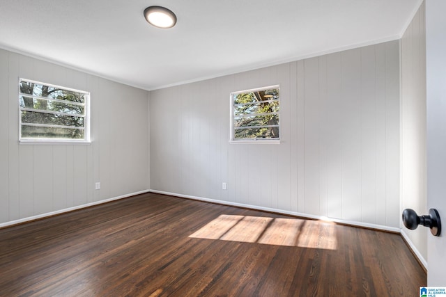 spare room featuring wood finished floors and baseboards