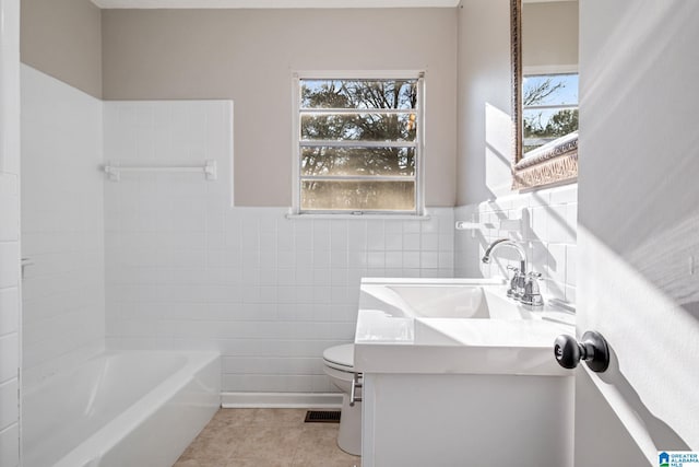 full bathroom featuring toilet, plenty of natural light, tile walls, and tile patterned floors