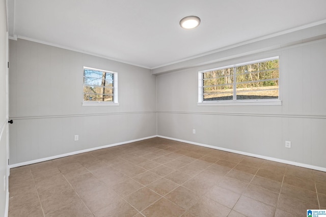 spare room with plenty of natural light, baseboards, and tile patterned floors