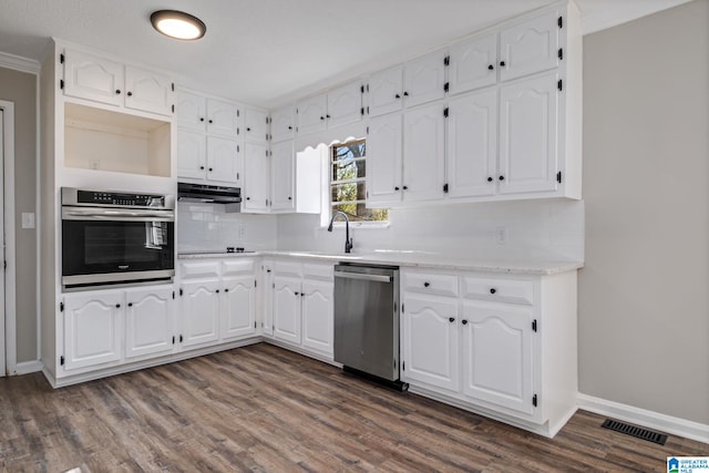 kitchen featuring stainless steel appliances, dark wood-style flooring, white cabinetry, and under cabinet range hood