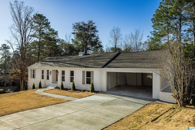 ranch-style house with concrete driveway, a carport, a chimney, and brick siding