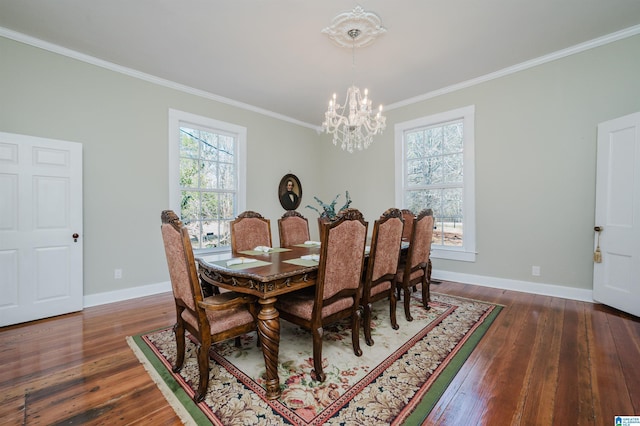 dining area with baseboards, ornamental molding, hardwood / wood-style flooring, and a notable chandelier