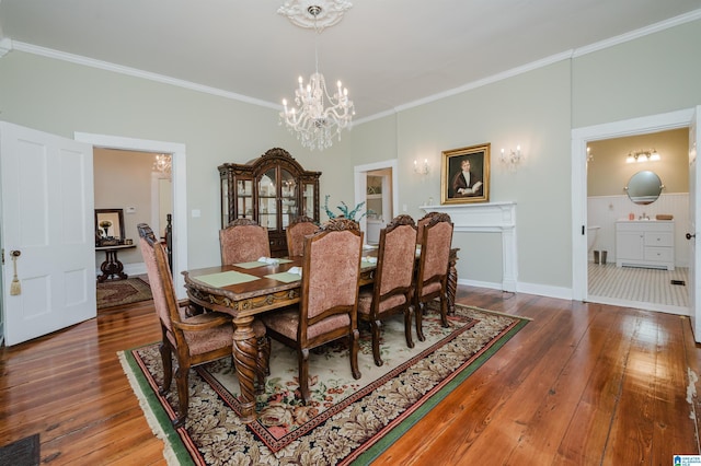 dining area featuring baseboards, visible vents, wood-type flooring, crown molding, and a notable chandelier