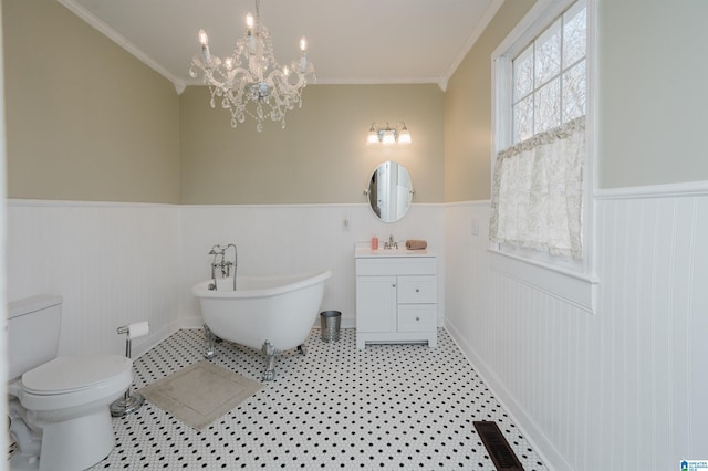 bathroom featuring toilet, a wainscoted wall, visible vents, vanity, and a freestanding bath