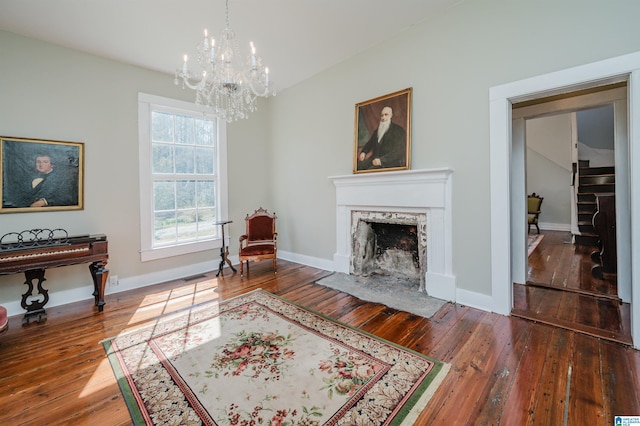 sitting room featuring a high end fireplace, hardwood / wood-style flooring, and baseboards