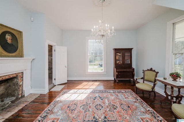 living area with hardwood / wood-style flooring, a fireplace with flush hearth, and baseboards