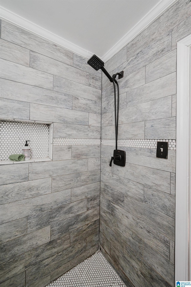 full bathroom featuring ornamental molding and a tile shower