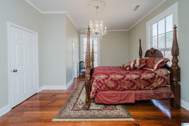 bedroom with visible vents, an inviting chandelier, ornamental molding, wood finished floors, and baseboards