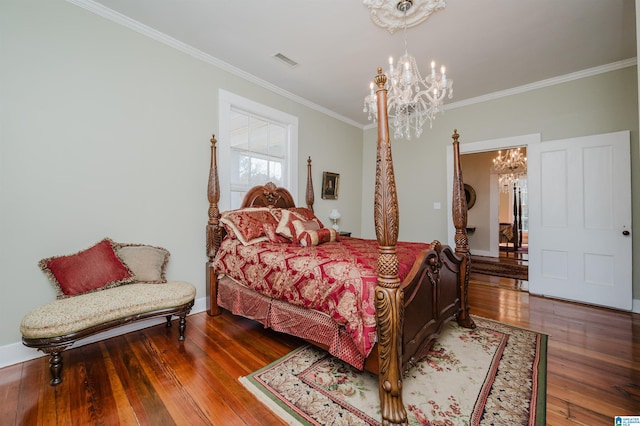 bedroom featuring an inviting chandelier, visible vents, ornamental molding, and hardwood / wood-style floors