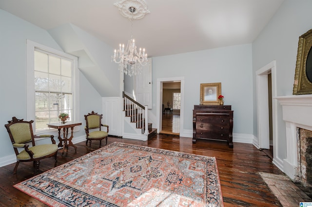 living area featuring hardwood / wood-style flooring, a fireplace with flush hearth, baseboards, and vaulted ceiling