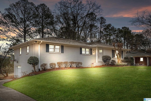 single story home featuring a garage, a front yard, and brick siding