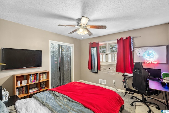 bedroom featuring baseboards, visible vents, ceiling fan, a textured ceiling, and carpet floors