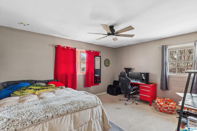 carpeted bedroom with multiple windows, baseboards, and a ceiling fan